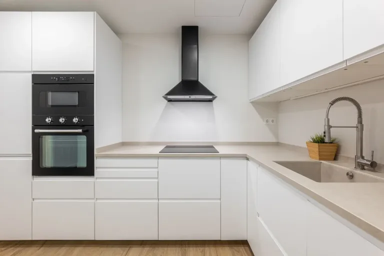 Cocina blanca con detalles modernos y extractor de aire