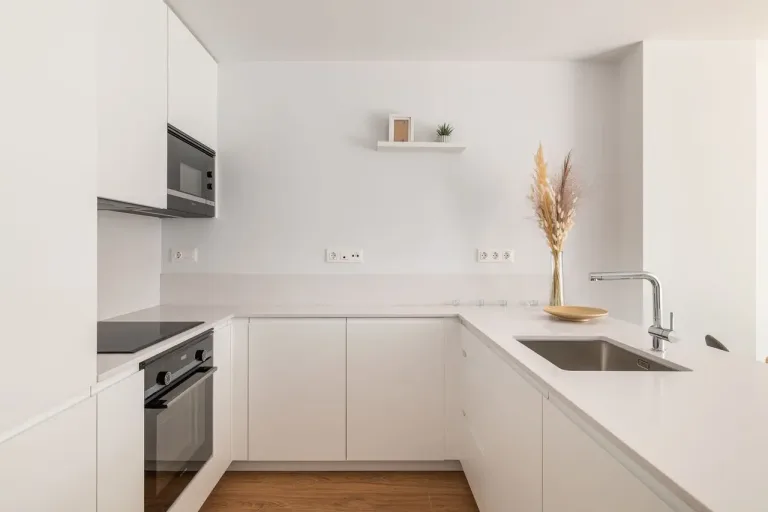 Cocina blanca minimalista con detalles en madera