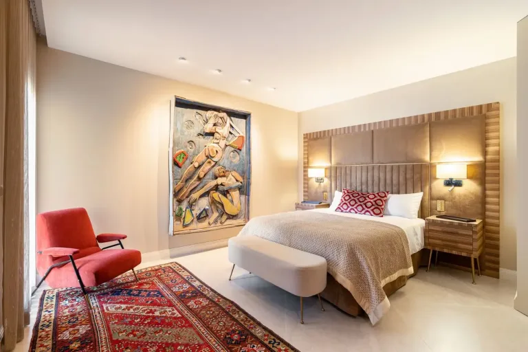 Dormitorio elegante con arte abstracto y alfombra oriental