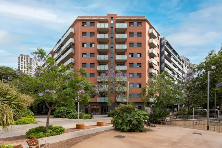 Edificio residencial con jardín y árboles floridos