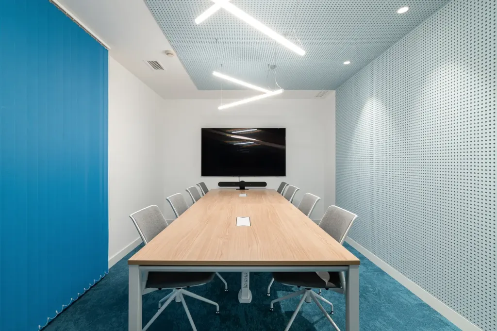 Sala de reuniones moderna con mesa de madera y sillas grises