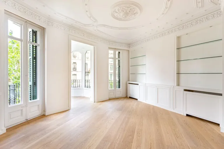 Salón clásico con molduras de techo y balcón francés