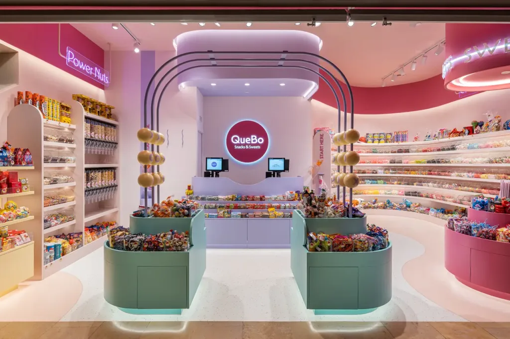 Tienda de dulces y aperitivos con decoración colorida y estantes llenos de productos