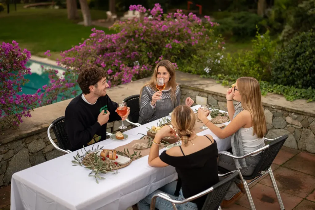 amigos cenando en terraza con flores