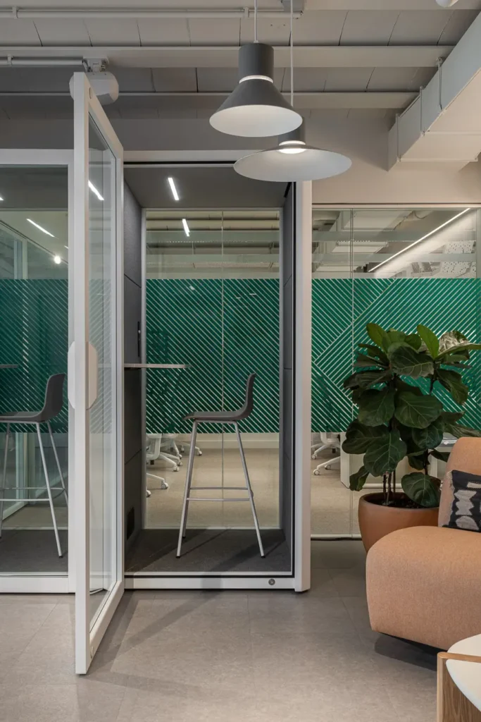 cabina telefonica abierta en oficina con plantas y mobiliario