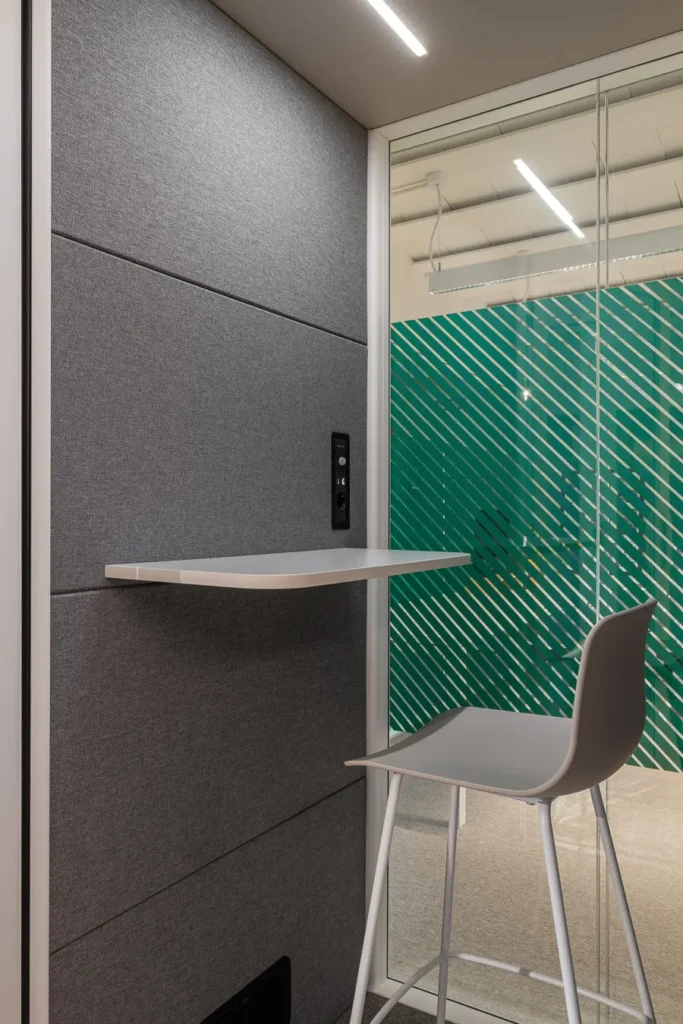 cabina telefonica en oficina con paneles grises y silla