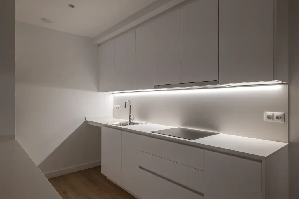 cocina elegante con iluminación led y muebles blancos