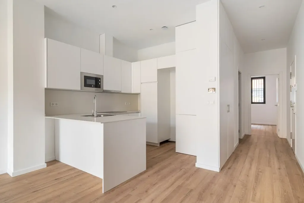 cocina moderna con muebles blancos y suelo de madera