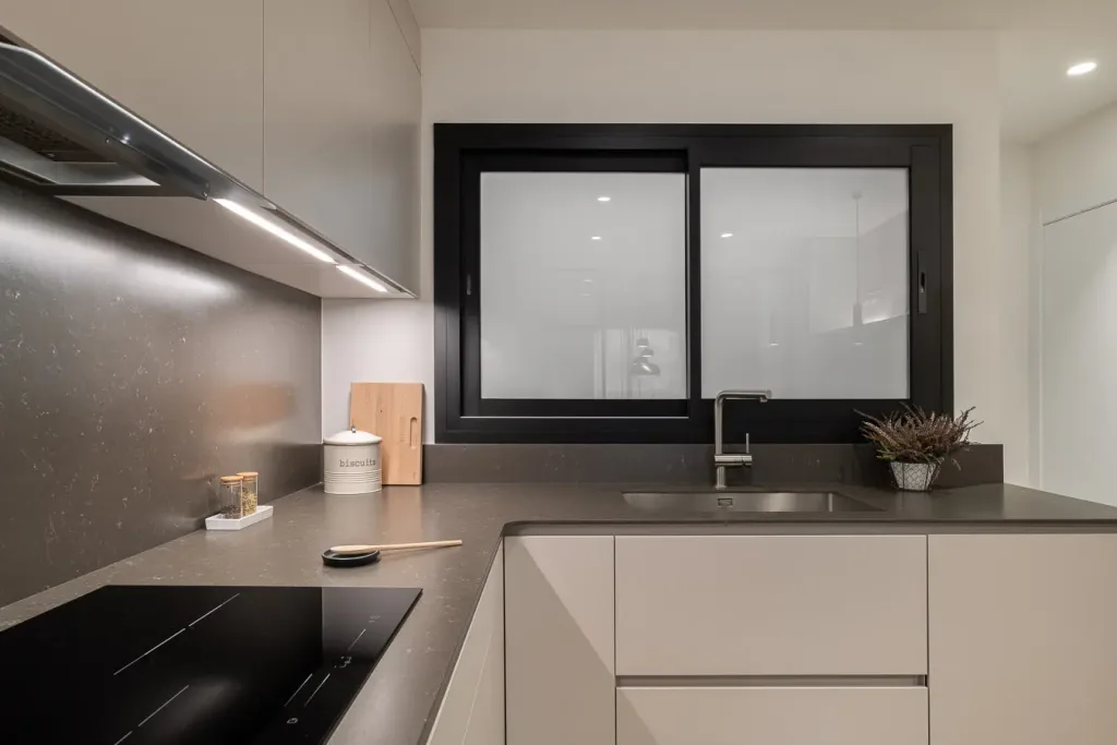 cocina elegante con ventana grande y encimeras oscuras
