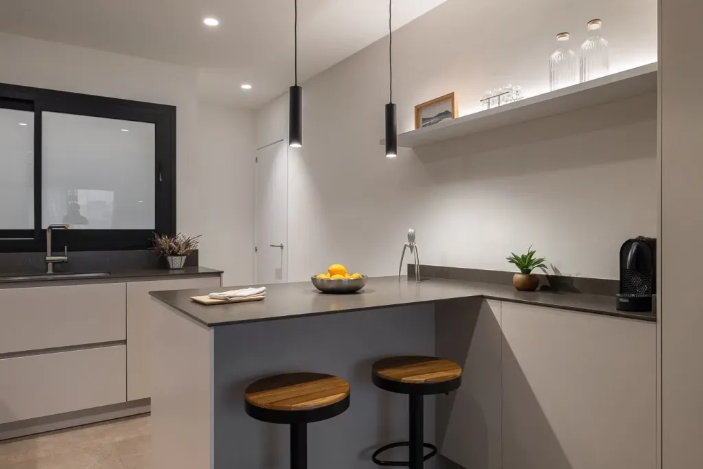 cocina minimalista con grandes armarios blanco hueso y electrodomesticos modernos