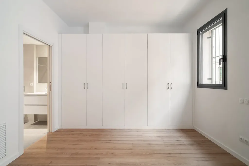 dormitorio con armario grande y ventana con vista a la ciudad