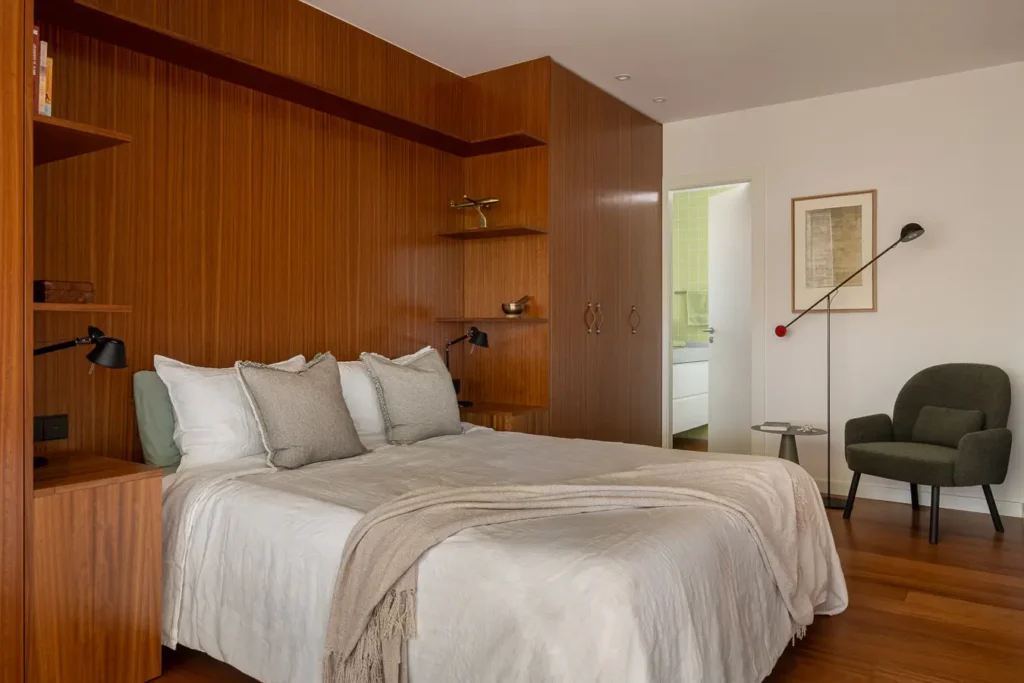 dormitorio principal con paredes de madera y cojinera