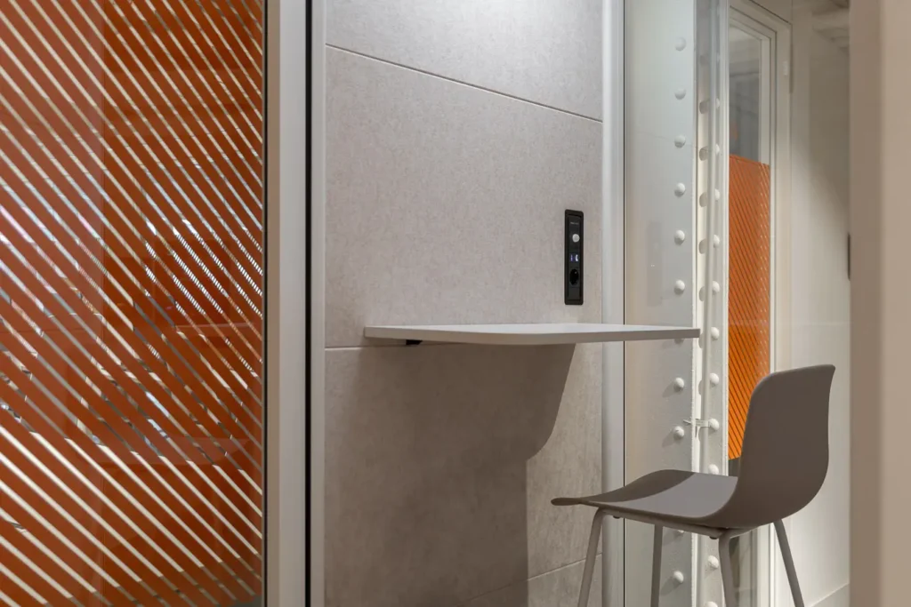 interior de cabina telefonica en oficina con silla y mesa