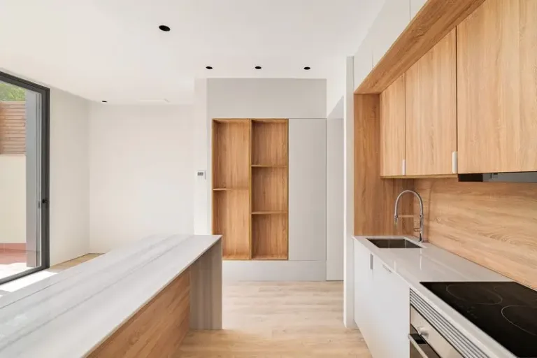 Interior de cocina moderna con isla y muebles de madera. Interior vacio de luminoso apartamento reformado 1