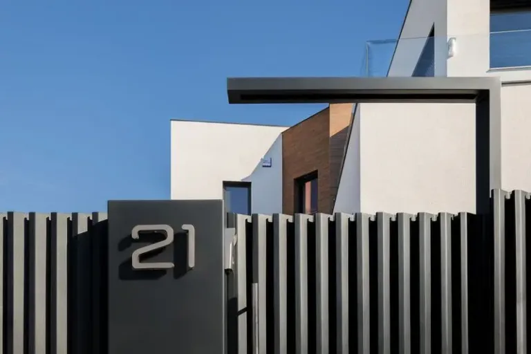 signo de numero en una valla frente a un edificio diseno exterior madera enrejada vertical negra