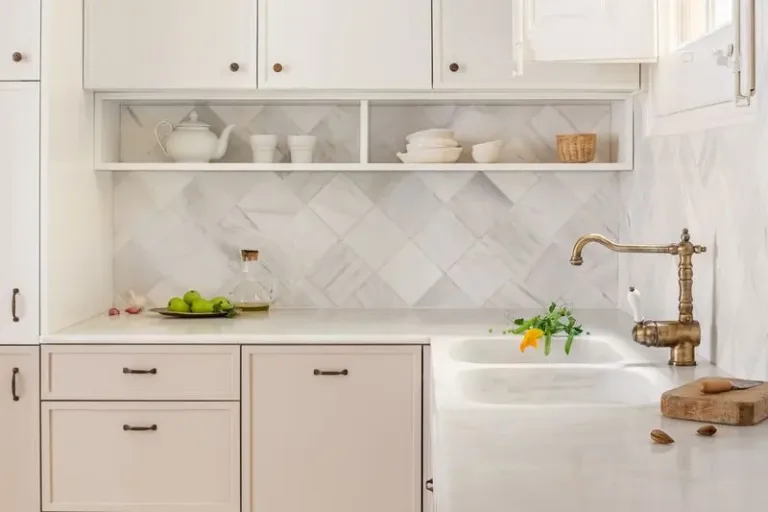 cocina clasica con fregadero y encimeras de marmol con flores y frutas frescas