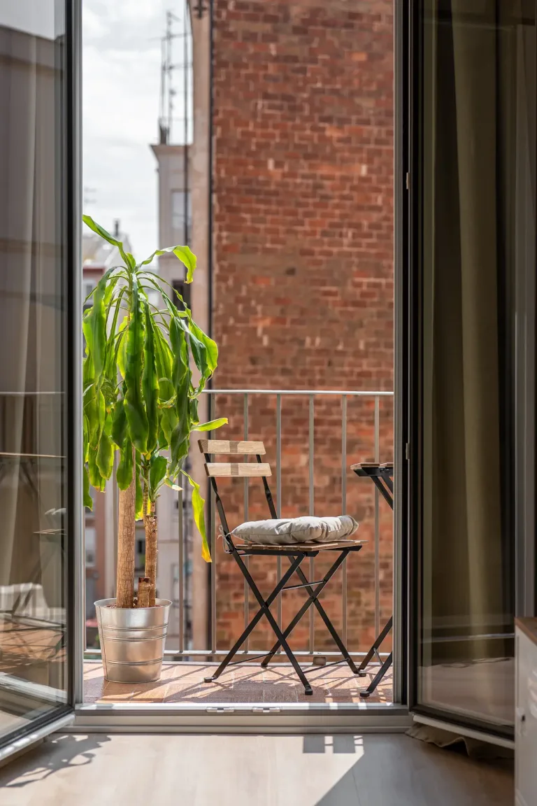 un acogedor balcon con una silla y una maceta