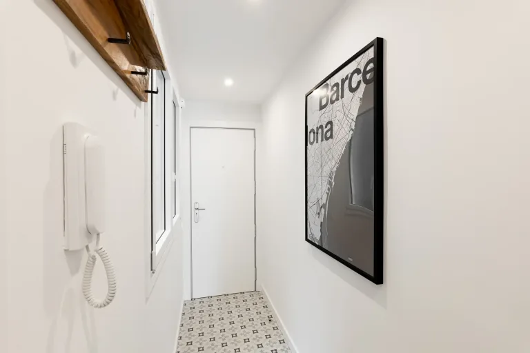 un pasillo con un telefono y una foto en la pared
