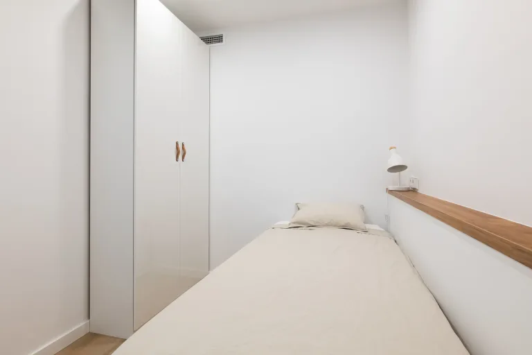 un pequeno dormitorio con una cama y un armario