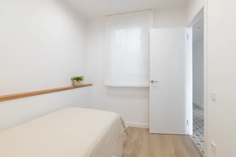 un pequeno dormitorio con una cama y una ventana