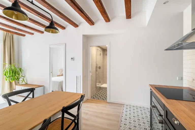 una cocina elegante con una mesa rustica de madera y sillas negras