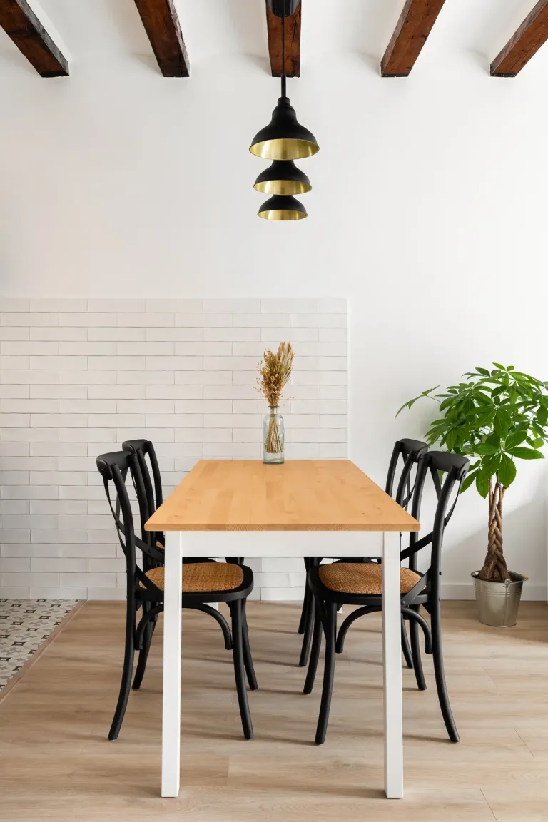 una mesa de comedor con sillas y una maceta en una habitacion bien iluminada