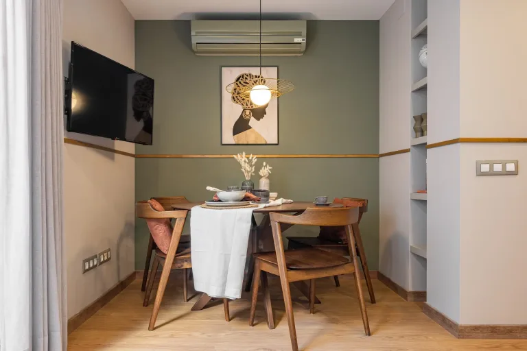 Acogedor interior domestico con mesa de comedor sillas e iluminacion ambiental en una habitacion pequena