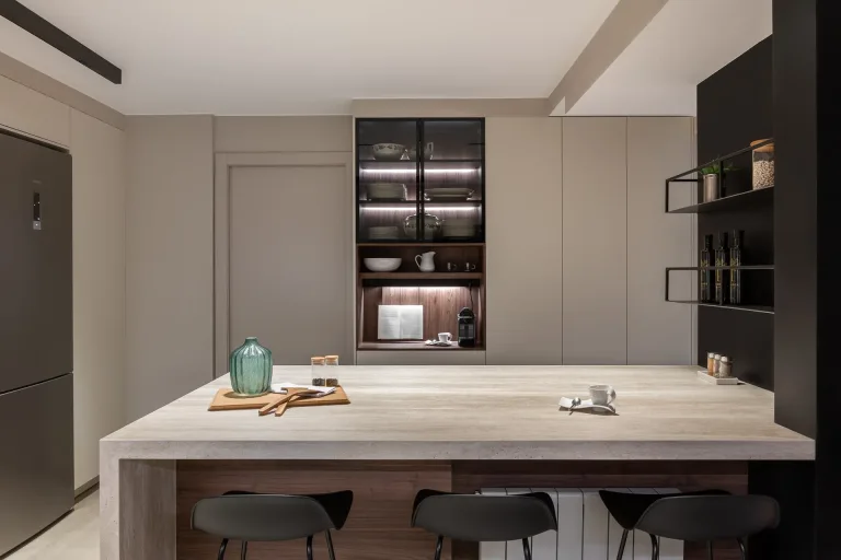 Cocina contemporanea con gabinetes iluminados encimera de marmol y detalles en tonos neutros