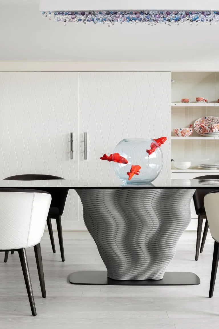 Detalle de mesa con pecera y sillas en un comedor moderno