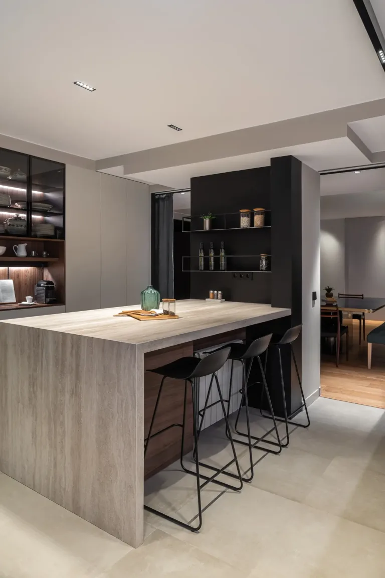 Diseno de cocina moderno con isla central taburetes elegantes y alacenas iluminadas