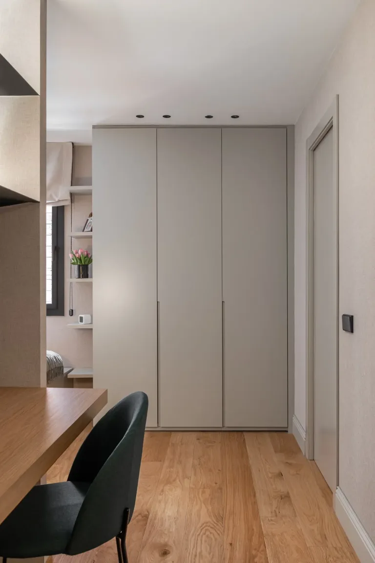 Diseno interior moderno con armario gris mesa de madera silla verde y detalles decorativos