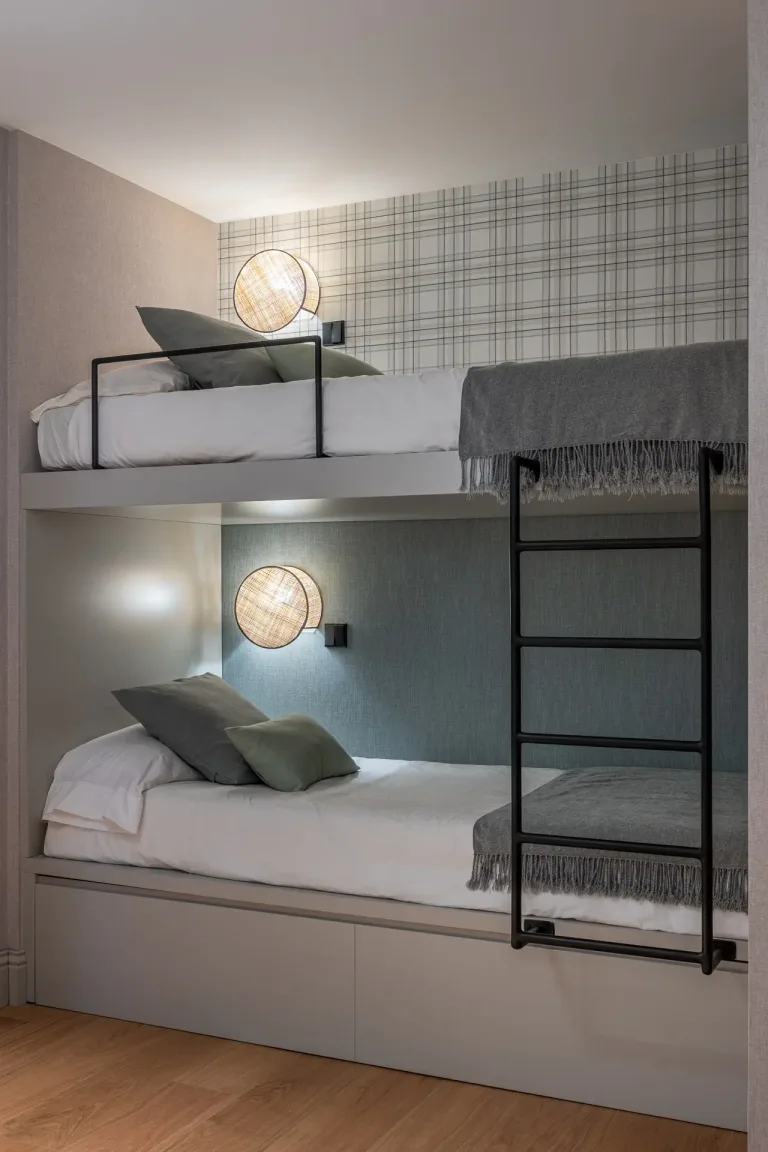Dormitorio contemporaneo con literas iluminacion de ratan y acentos en tonos neutros