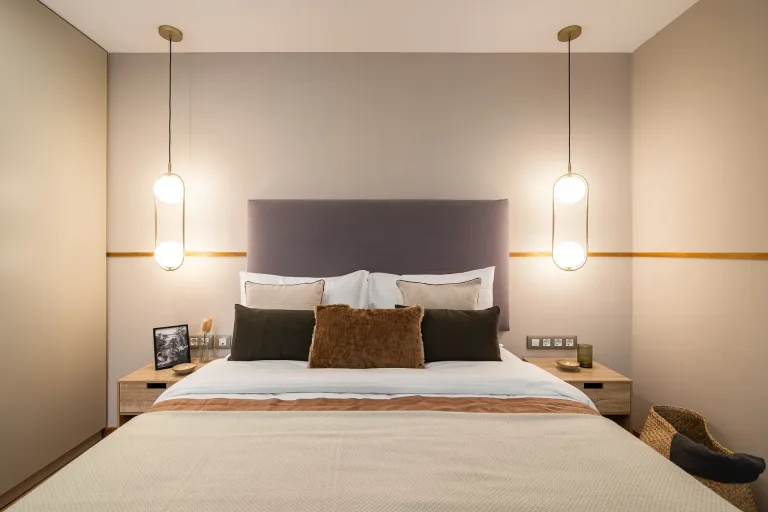 Dormitorio en suite de lujo con elegantes muebles e iluminacion ambiental