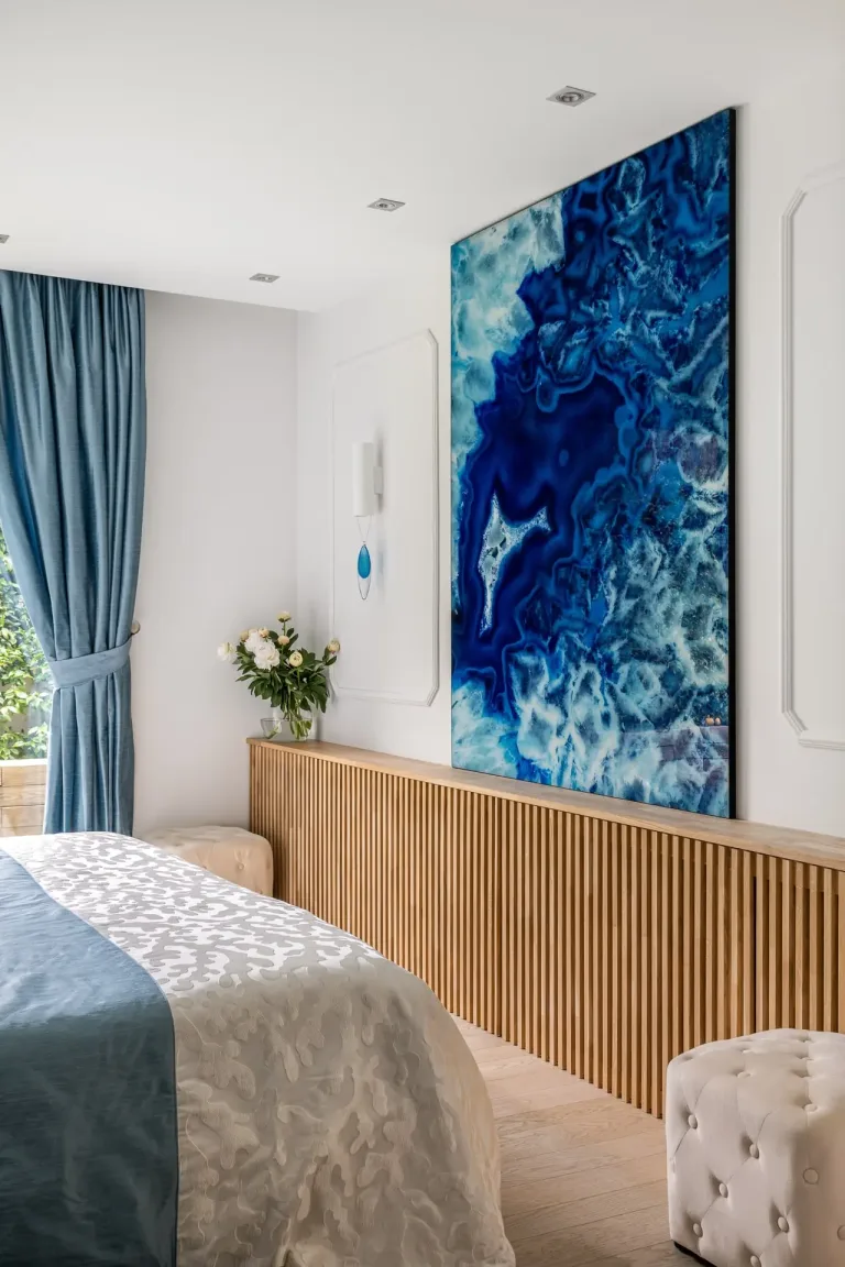 Espacio sereno con tonos azules cuadro abstracto detalles en madera y cortina elegante