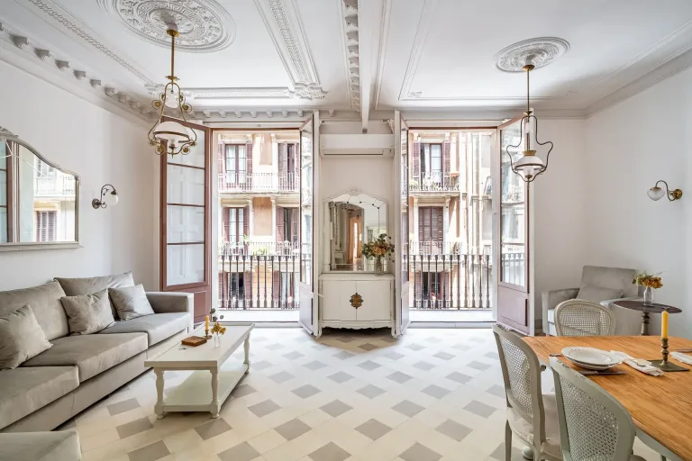Interior elegante en estilo barroco. Salon con lamparas de arana un sofa sillas y mesa de comedor de madera