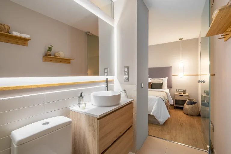 Lujoso interior de casa con espejo y lavabo en el bano con vistas al dormitorio