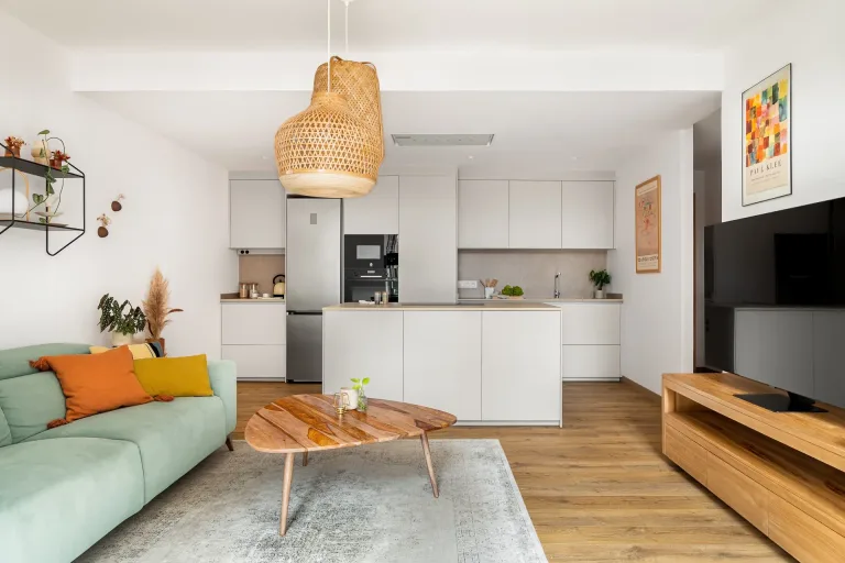 Sala de estar moderna con un sofa mesa de centro de madera y cocina americana