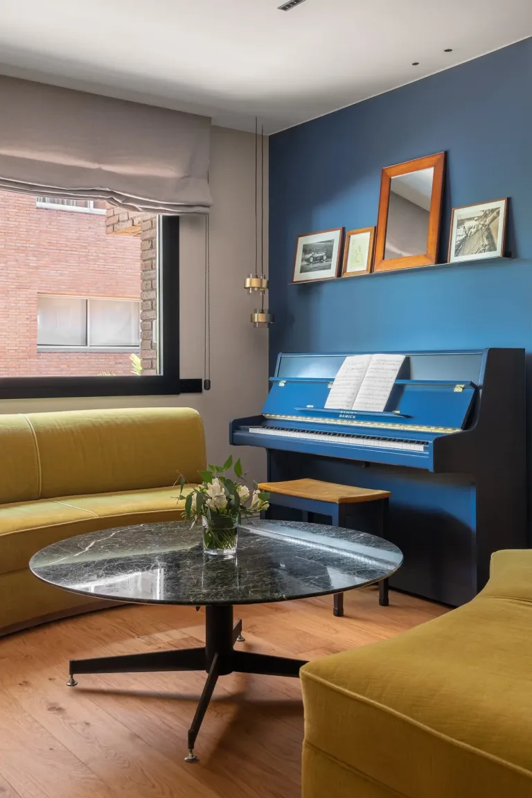 Sala moderna con sofa amarillo piano azul y mesa de centro de marmol