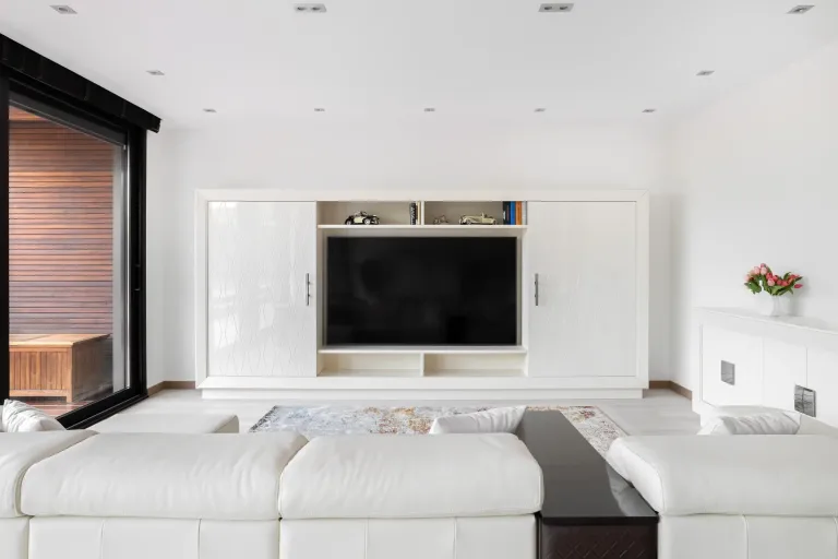 Sala moderna con television empotrada sofa blanco y detalles en madera