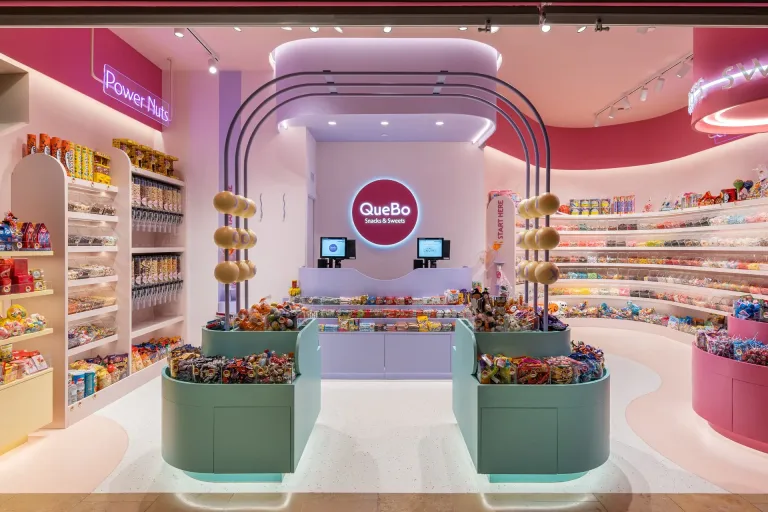 Tienda QueBo Snacks Sweets con una variedad de golosinas y snacks en estantes y mostradores min