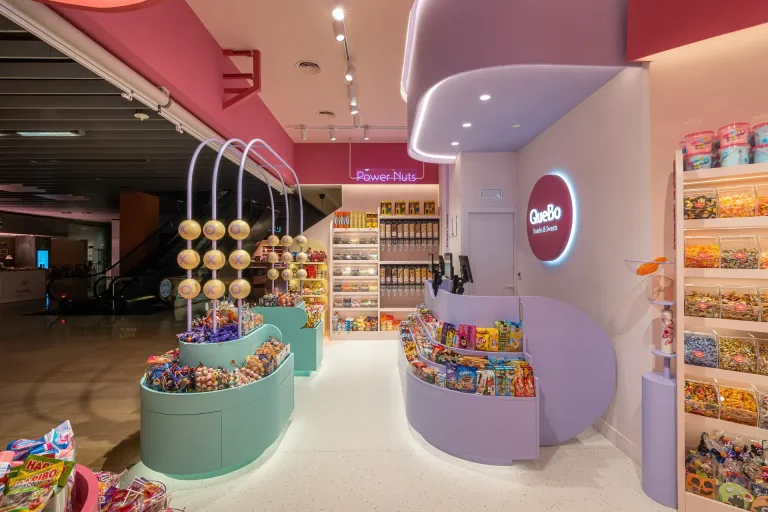 Tienda QueBo con dulces variados estantes llenos y diseno moderno en tonos rosados y morados min