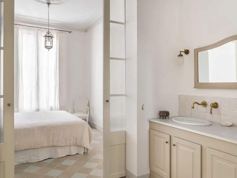 bano con lavabo espejo y vista a un dormitorio combinacion de colores crema y blanco