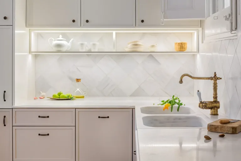cocina clasica con fregadero y encimeras de marmol con flores y frutas frescas
