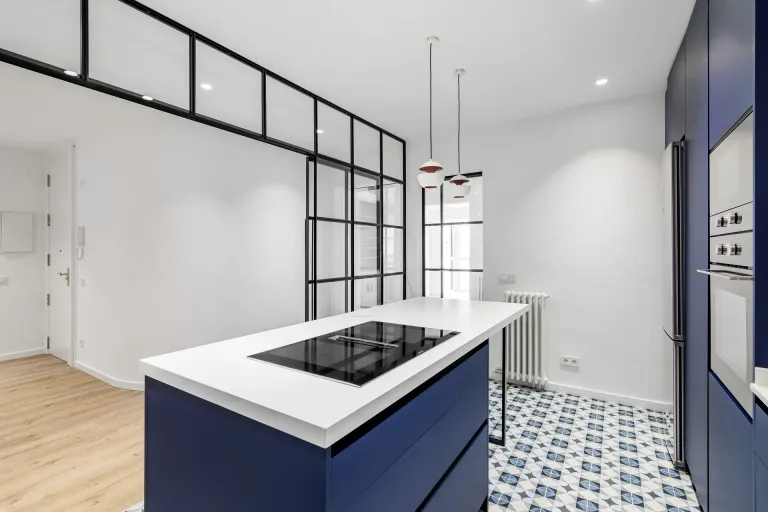 cocina moderna con isla de cocina estufa y gabinetes azules