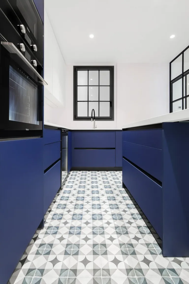 cocina nueva y moderna con un mostrador blanco y gabinetes azules