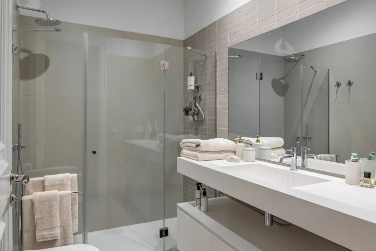cuarto de bano moderno y limpio con puerta de ducha de cristal lavabo espejo