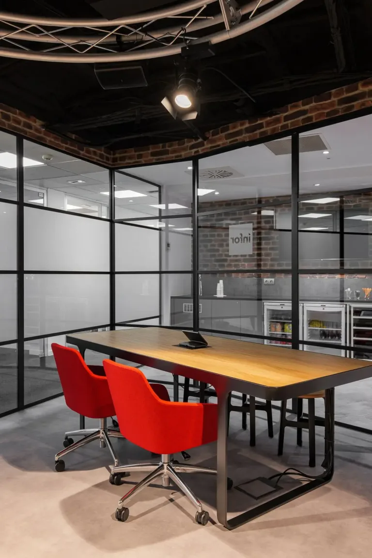 dos sillas rojas y una mesa de madera en una habitacion de una oficina de diseno industrial