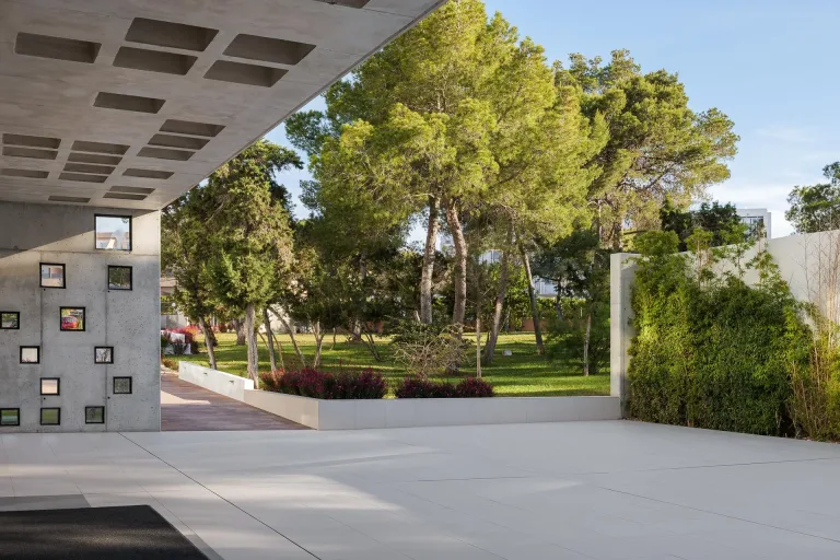 entrada de un hotel con hermoso jardin en una tarde soleada