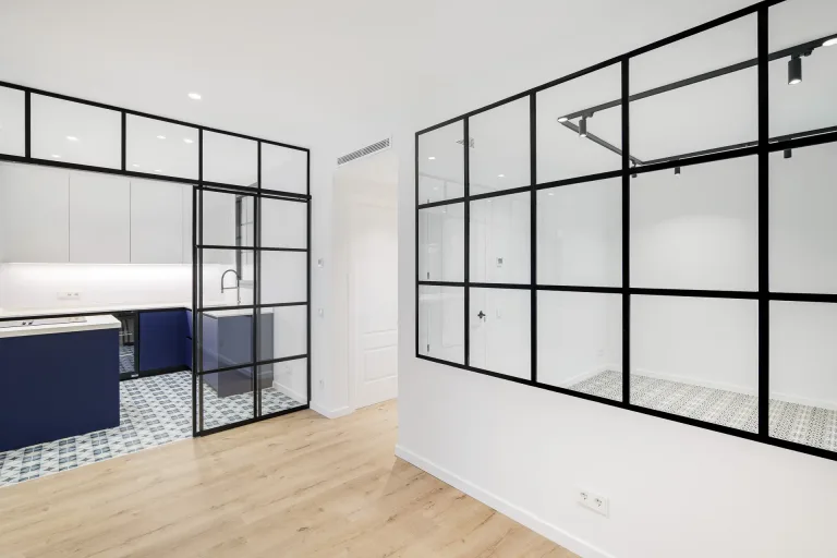 gran ventana negra en la entrada de un apartamento nuevo con cocina de colores blanco y azul