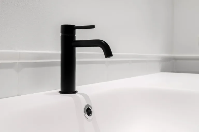 grifo negro en un lavabo blanco en un bano nuevo de un apartamento moderno